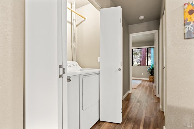 washroom featuring independent washer and dryer, hardwood / wood-style floors, baseboards, and laundry area