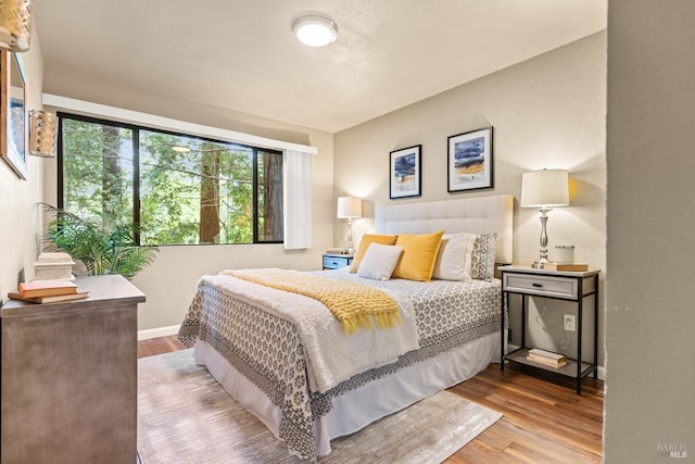 bedroom with wood finished floors and baseboards