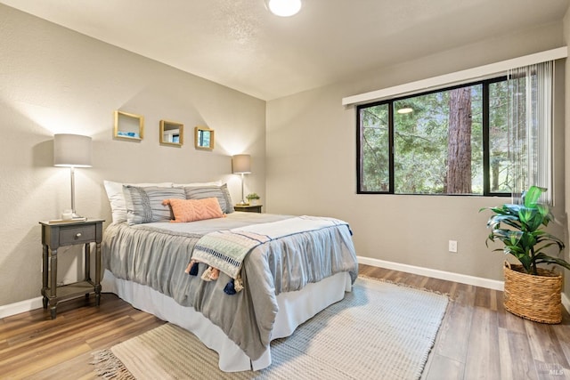 bedroom featuring wood finished floors and baseboards