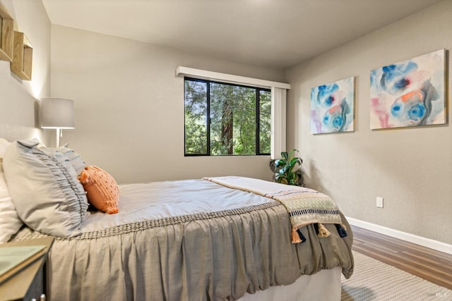 bedroom with baseboards and wood finished floors