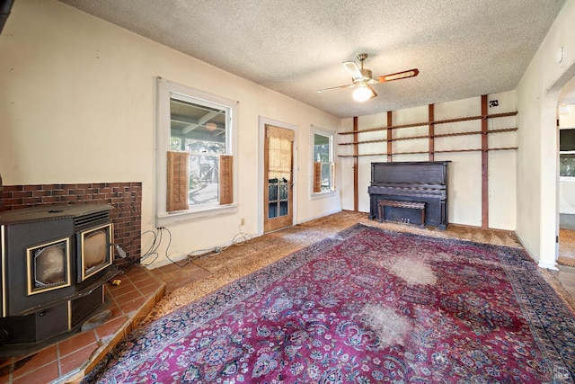 735 Robinson Rd, Sebastopol, CA 95472 - living area with a textured ceiling, a wood stove, and a ceiling fan