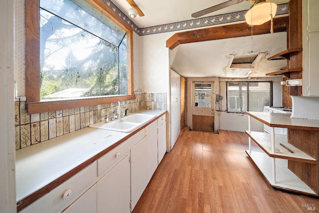 735 Robinson Rd, Sebastopol, CA 95472 - kitchen with white cabinets, backsplash, light countertops, a sink, and light wood-type flooring
