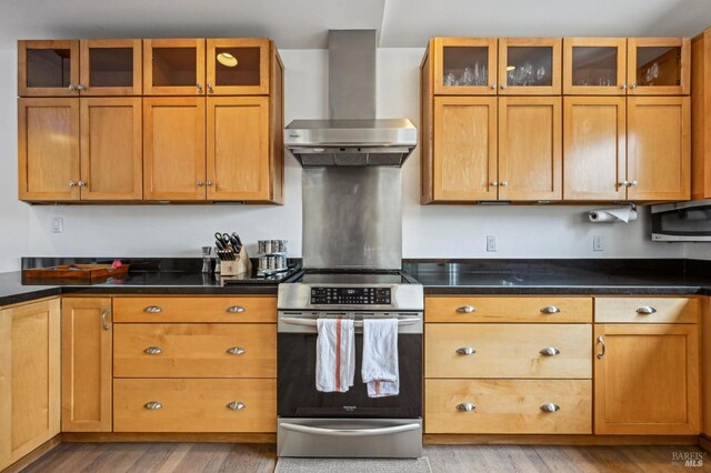 1 Joaquin Patio, Stinson Beach, CA 94970 - kitchen with wall chimney range hood, stainless steel range with electric cooktop, glass insert cabinets, and light wood finished floors