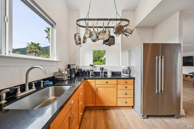 1 Joaquin Patio, Stinson Beach, CA 94970 - kitchen with a sink, light wood-style floors, brown cabinets, high end refrigerator, and dark stone countertops