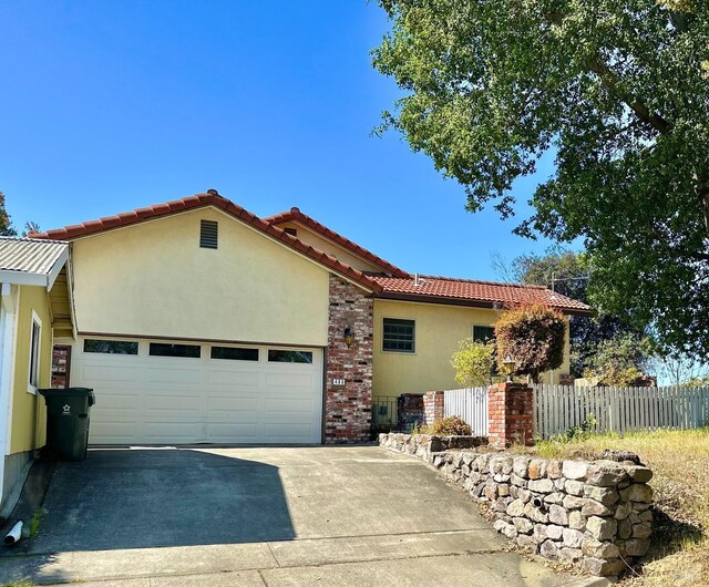 639 E 5th St, Benicia, CA 94510 - view of front of house with concrete driveway, a garage, stucco siding, and a tiled roof