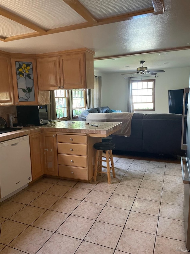 639 E 5th St, Benicia, CA 94510 - kitchen with white dishwasher, tile countertops, a peninsula, light tile patterned floors, and open floor plan