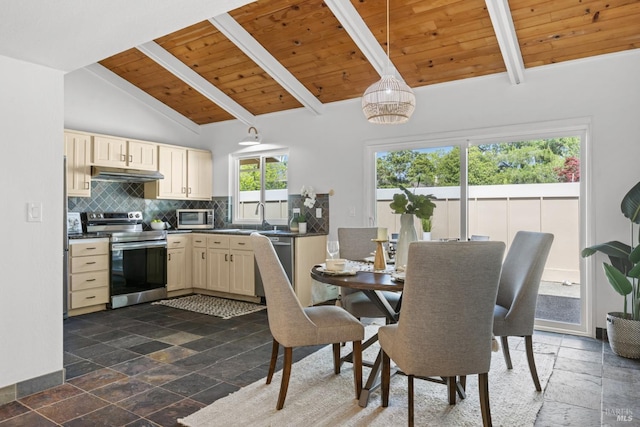 kitchen featuring wood ceiling, stone tile floors, stainless steel appliances, under cabinet range hood, and vaulted ceiling with beams