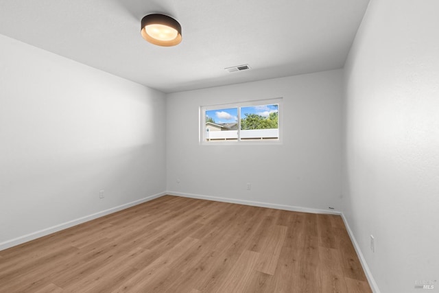 unfurnished room featuring visible vents, baseboards, and light wood-style floors