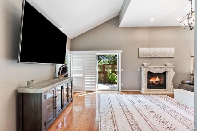 unfurnished living room with light wood finished floors, recessed lighting, high vaulted ceiling, and a fireplace