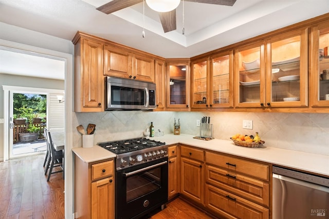 kitchen with stainless steel appliances, light countertops, and brown cabinetry