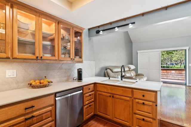 kitchen featuring a sink, decorative backsplash, a peninsula, light countertops, and dishwasher