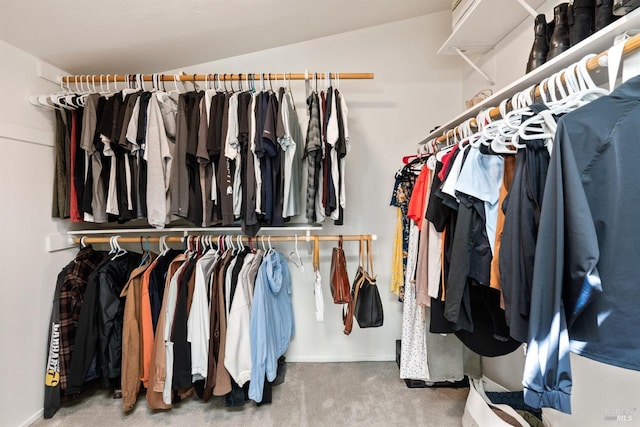 walk in closet featuring vaulted ceiling and carpet floors