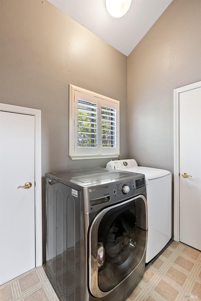 washroom featuring light floors, separate washer and dryer, and laundry area