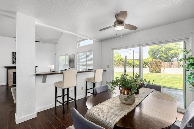dining room with a textured ceiling, ceiling fan, wood finished floors, and baseboards