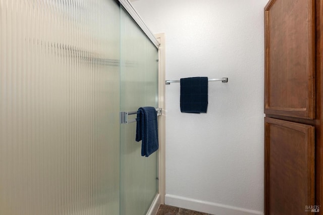 full bath featuring baseboards and a stall shower