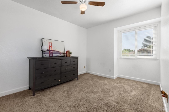 carpeted bedroom with ceiling fan and baseboards