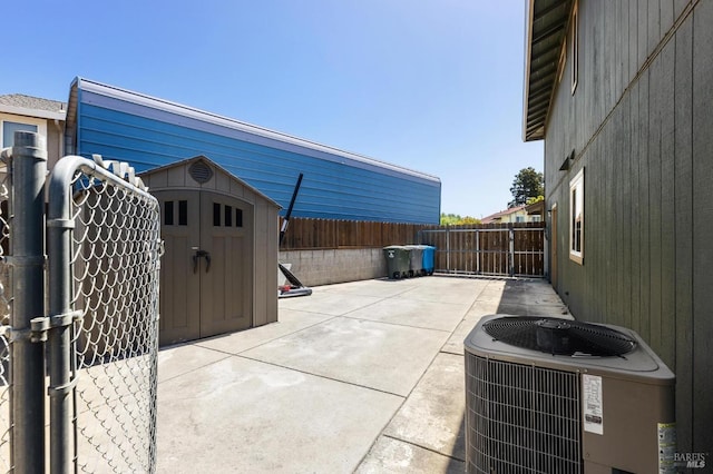 view of patio featuring a fenced backyard, a shed, an outbuilding, and central air condition unit