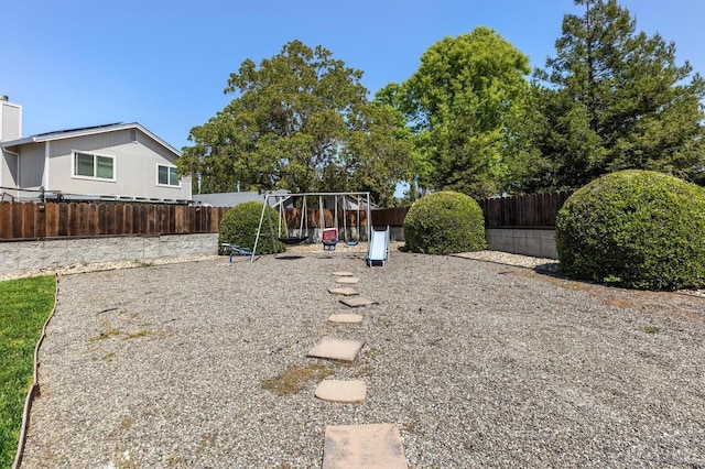 view of yard with a fenced backyard and a playground