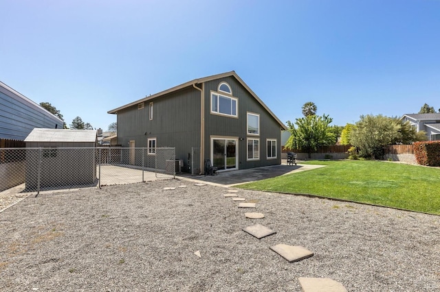 rear view of house featuring a lawn, a fenced backyard, and a patio area
