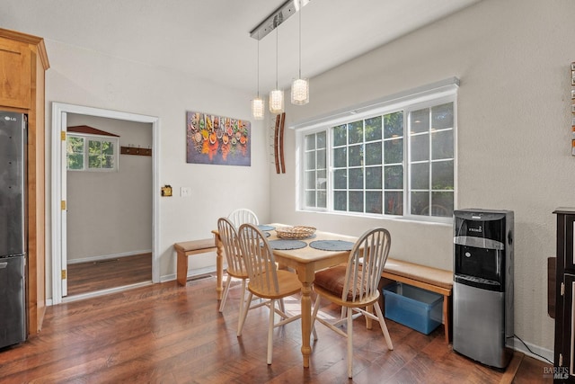 dining space featuring dark wood-style flooring and baseboards