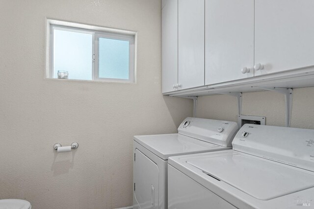 laundry room with washer and clothes dryer and cabinet space