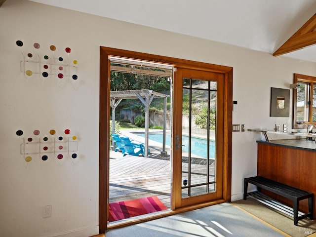 doorway featuring baseboards and carpet floors