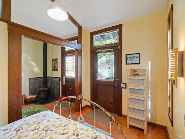 entrance foyer with a wood stove and baseboards