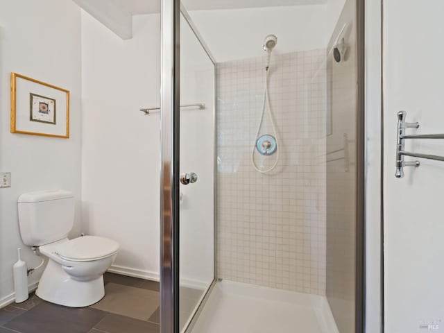 bathroom with tile patterned floors, a shower stall, and toilet