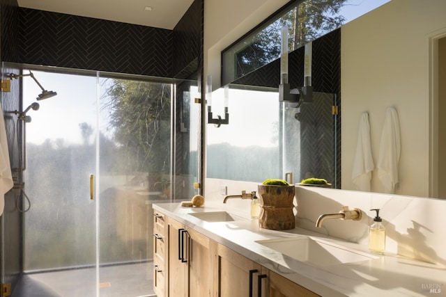 bathroom featuring plenty of natural light, a sink, and a stall shower