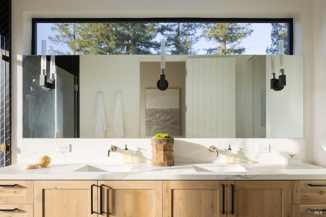 bathroom with double vanity, a sink, and a wealth of natural light