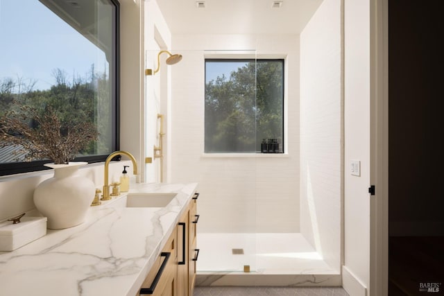 full bath featuring vanity and a tile shower