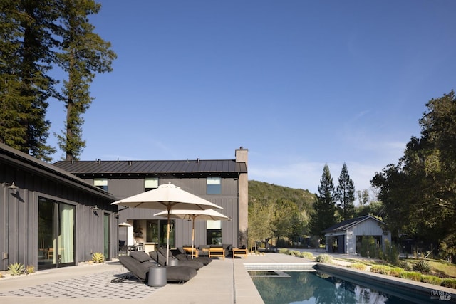 outdoor pool with a patio and an outdoor hangout area