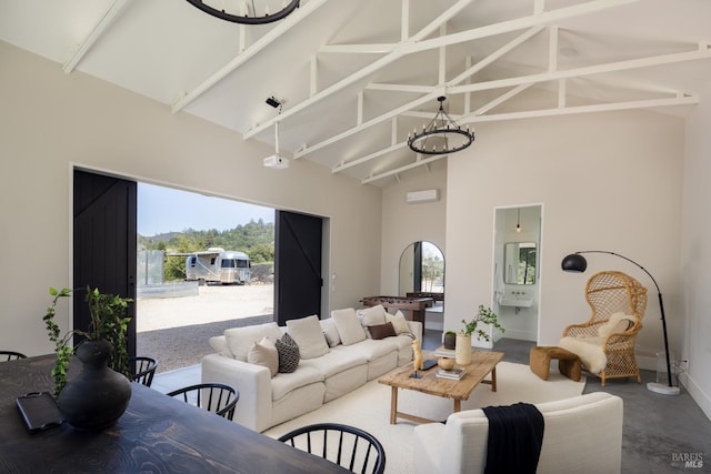 living room featuring high vaulted ceiling, a notable chandelier, and baseboards