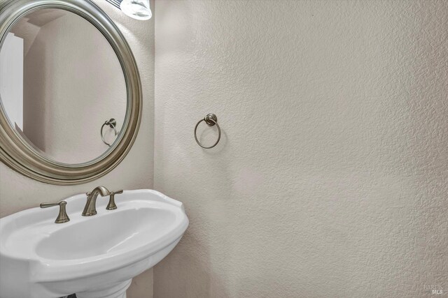 bathroom with a textured wall and a sink
