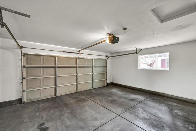 garage with a garage door opener and baseboards
