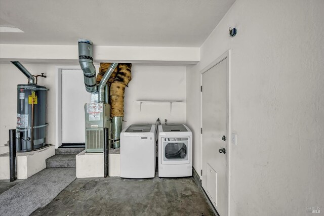 clothes washing area with water heater, laundry area, and washing machine and dryer