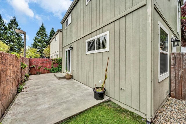 view of side of property featuring a patio and a fenced backyard