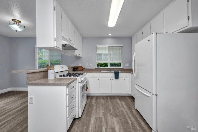kitchen featuring wood finished floors, white appliances, white cabinetry, and under cabinet range hood