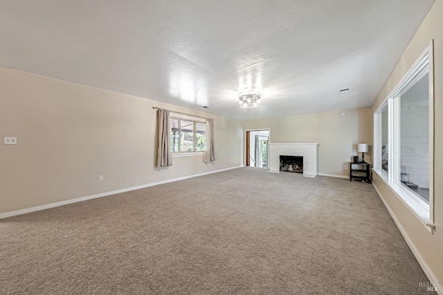 unfurnished living room featuring a fireplace, light colored carpet, visible vents, and baseboards