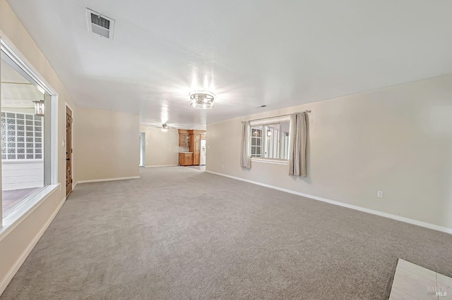 unfurnished living room with baseboards, visible vents, a ceiling fan, and carpet flooring