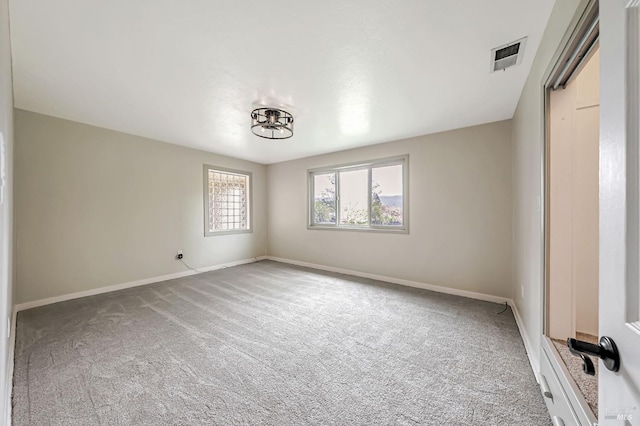 carpeted empty room featuring visible vents and baseboards