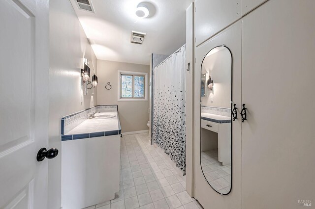 full bath with toilet, tile patterned flooring, visible vents, and vanity