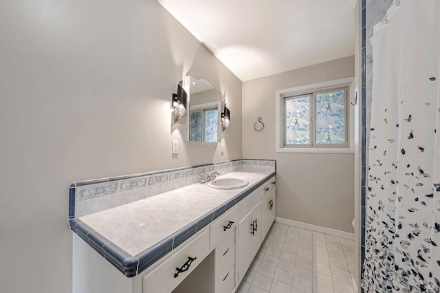 bathroom with vanity, a shower with curtain, tile patterned flooring, and baseboards