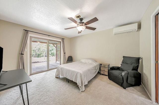 bedroom featuring access to exterior, light carpet, a textured ceiling, and an AC wall unit