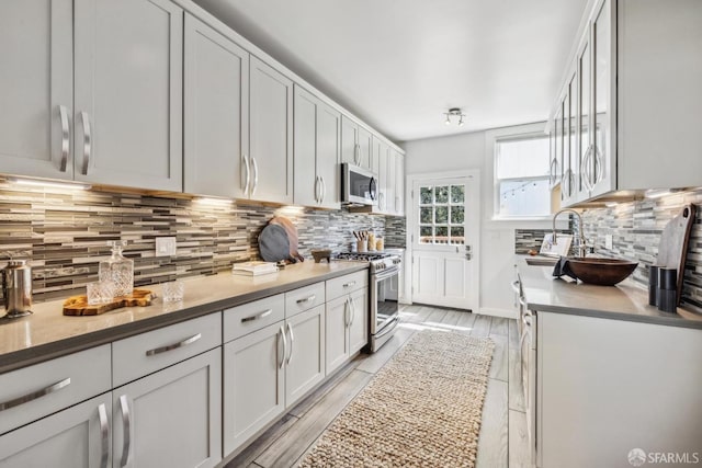 22 Wood St, San Francisco, CA 94118 - kitchen featuring a sink, stainless steel appliances, white cabinetry, backsplash, and light countertops
