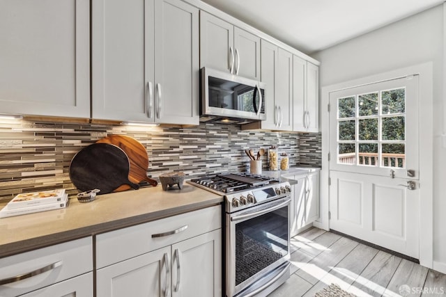 22 Wood St, San Francisco, CA 94118 - kitchen featuring decorative backsplash, light countertops, white cabinets, and appliances with stainless steel finishes