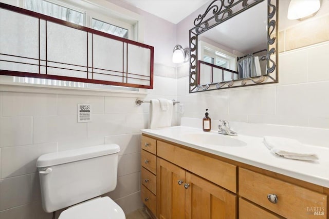 full bathroom with tile walls, toilet, and vanity