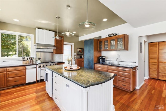kitchen with recessed lighting, glass insert cabinets, light wood-type flooring, a kitchen island, and white cabinets