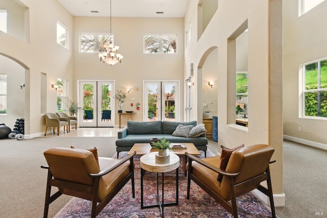 401 N Ave Unit 310, San Rafael, CA 94903 - carpeted living room featuring french doors, a towering ceiling, arched walkways, baseboards, and a notable chandelier
