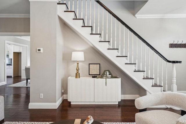 stairs with crown molding, wood finished floors, and baseboards